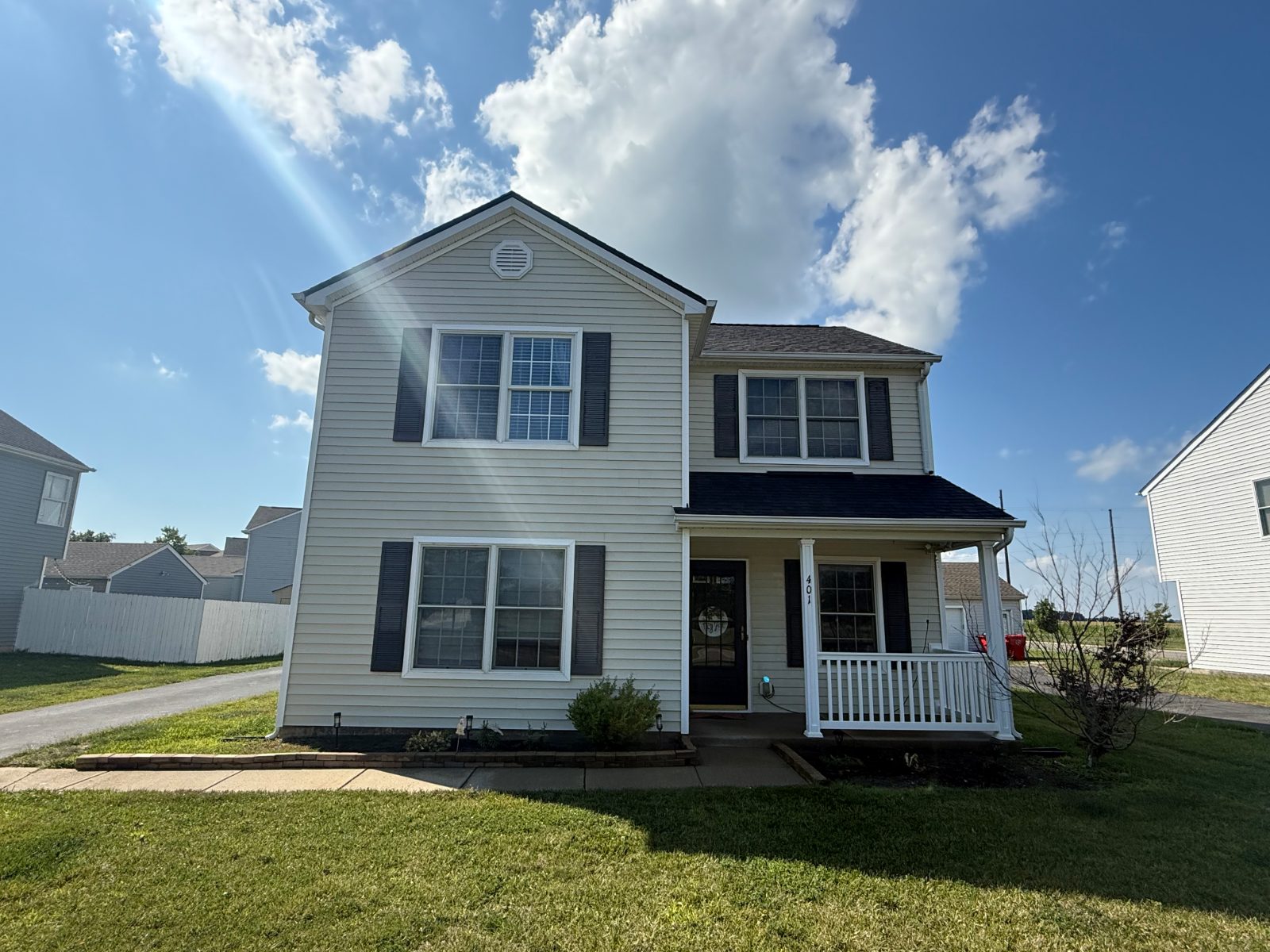Two-story home with cream siding and a white porch after a soft wash in Summerford, OH