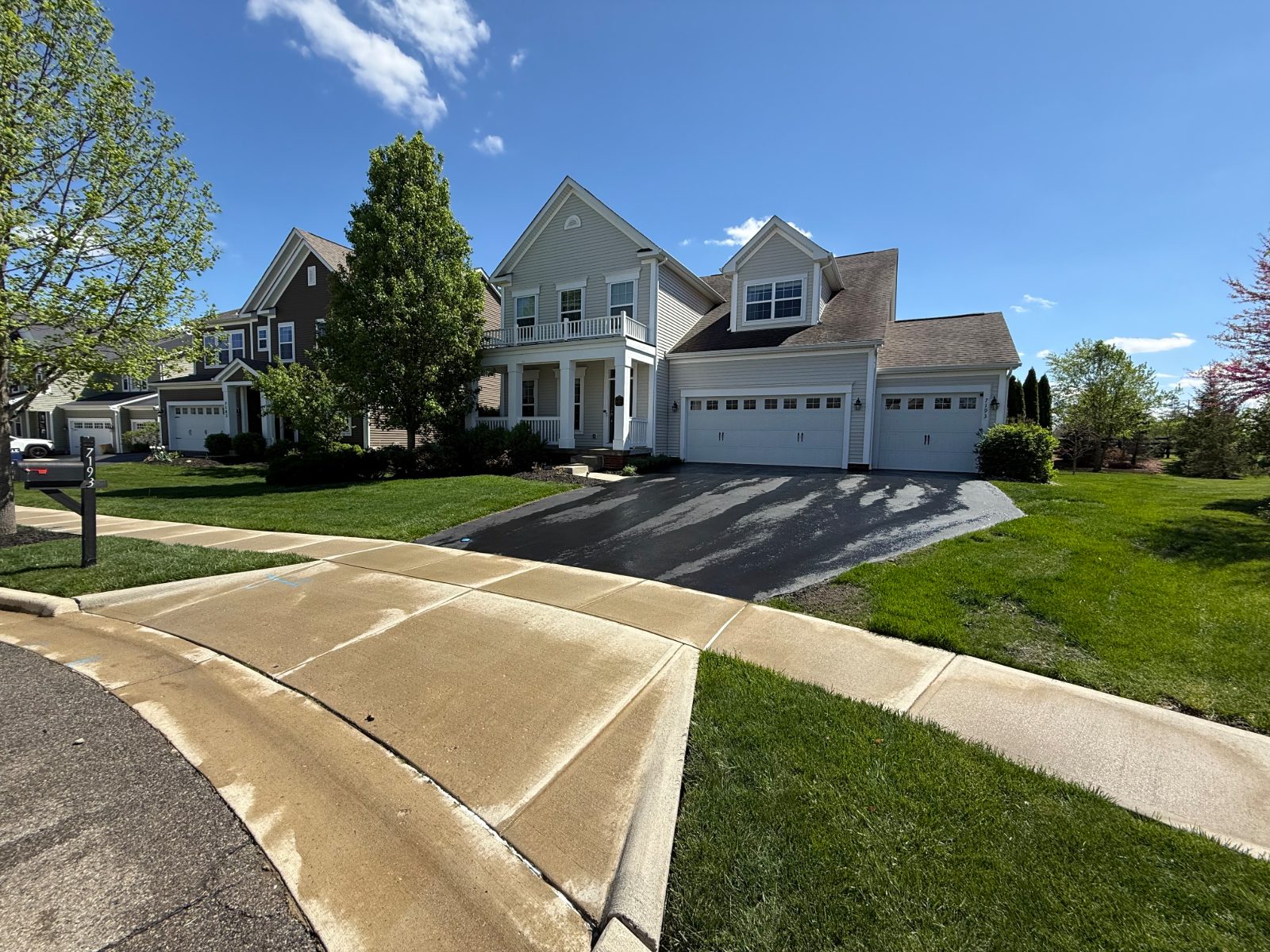 Clean concrete driveway and front sidewalk at a two-story home in Jerome, OH
