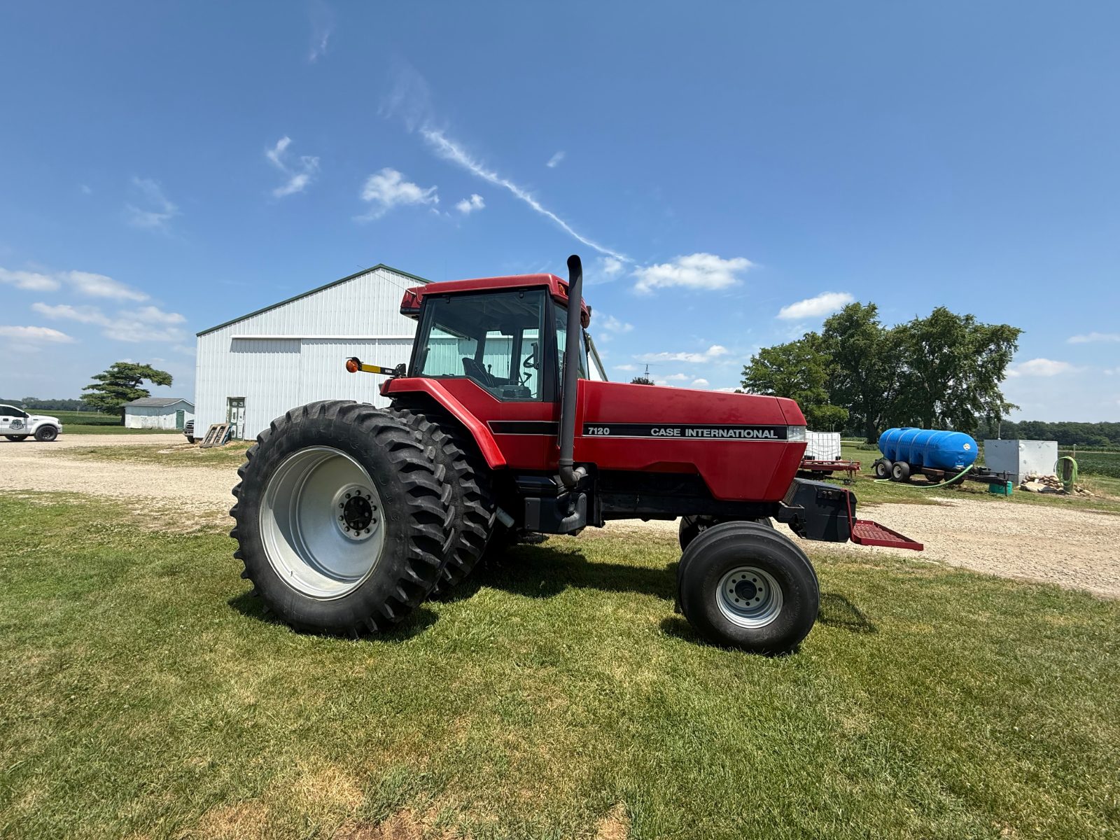 Red farm tractor cleaned on-farm beside a pole barn in Central Ohio