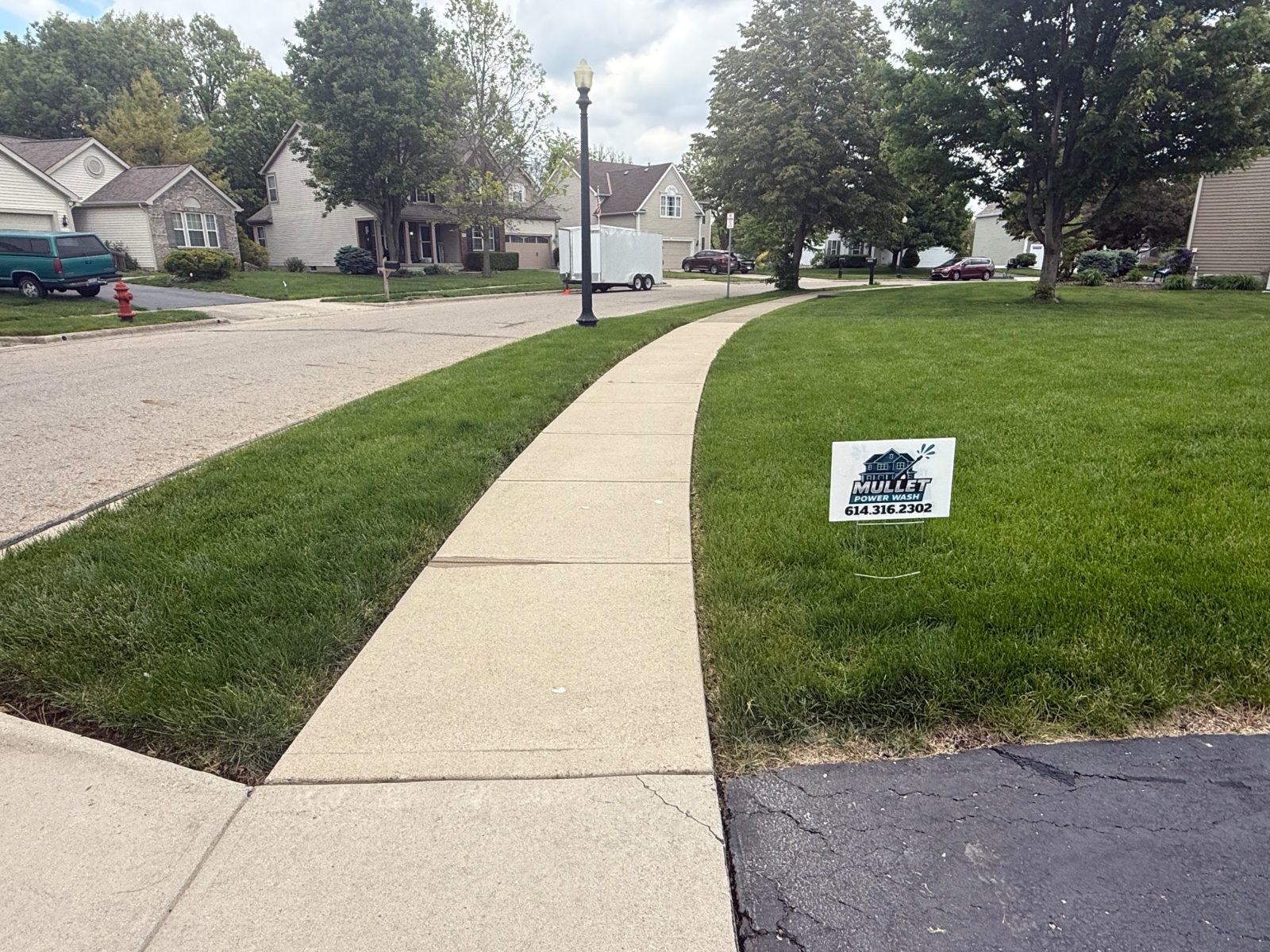 Freshly pressure washed concrete driveway apron and front walk in Central Ohio
