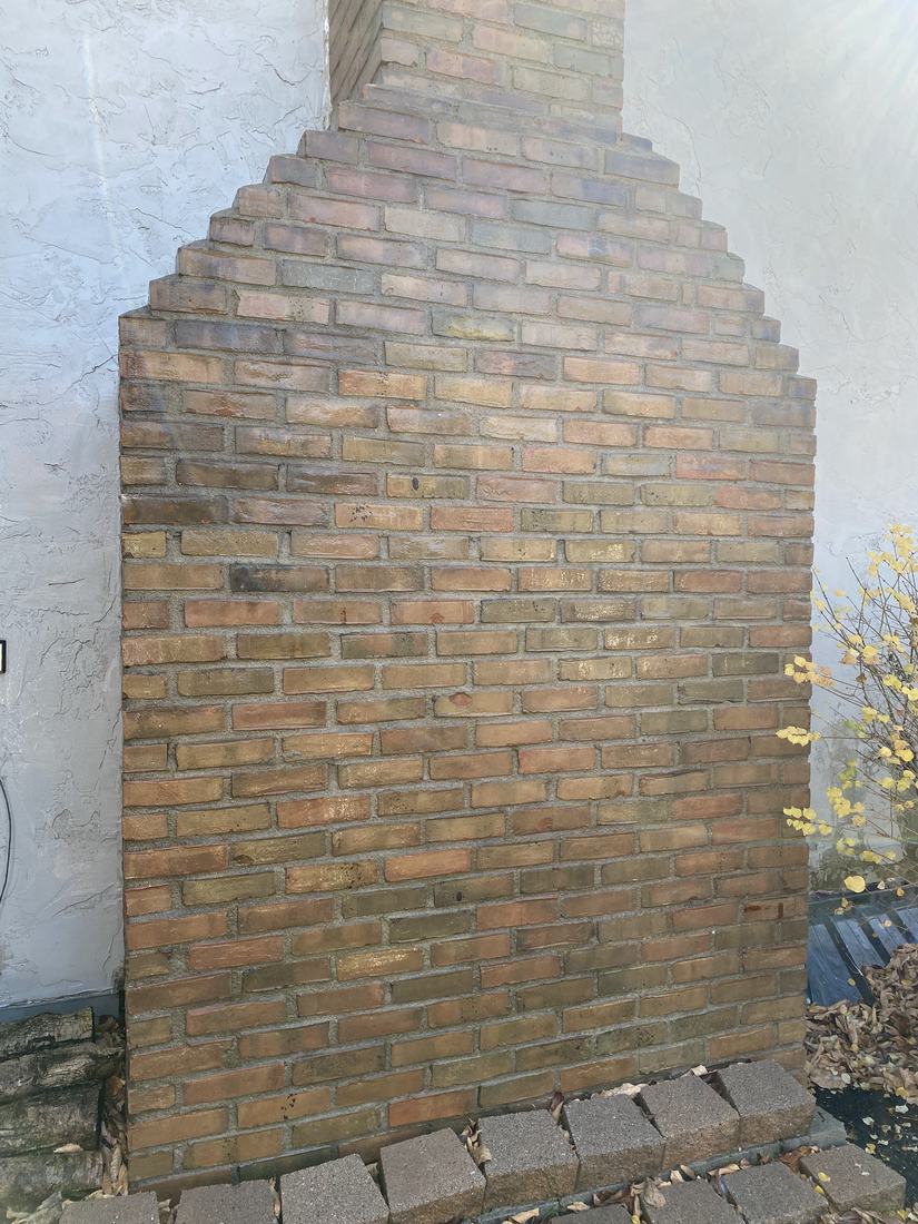 Brick chimney on a stucco home after washing by Mullet Power Wash