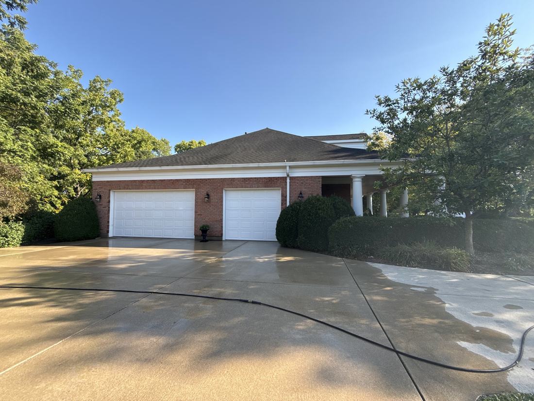 Freshly washed concrete driveway in front of a brick ranch home in Central Ohio
