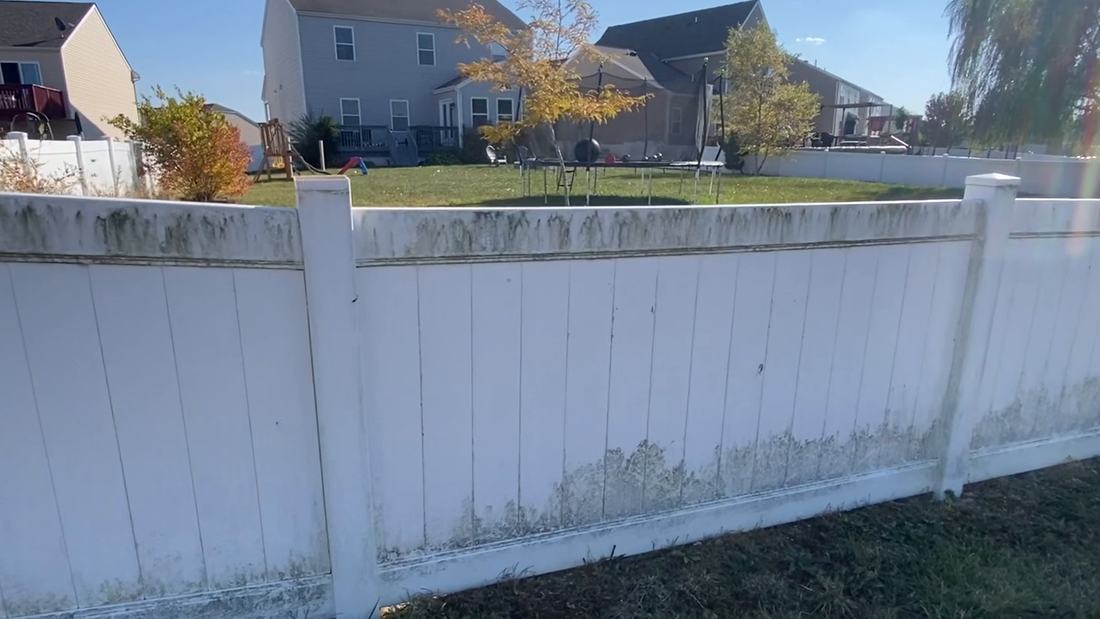 A vinyl privacy fence run before fence washing