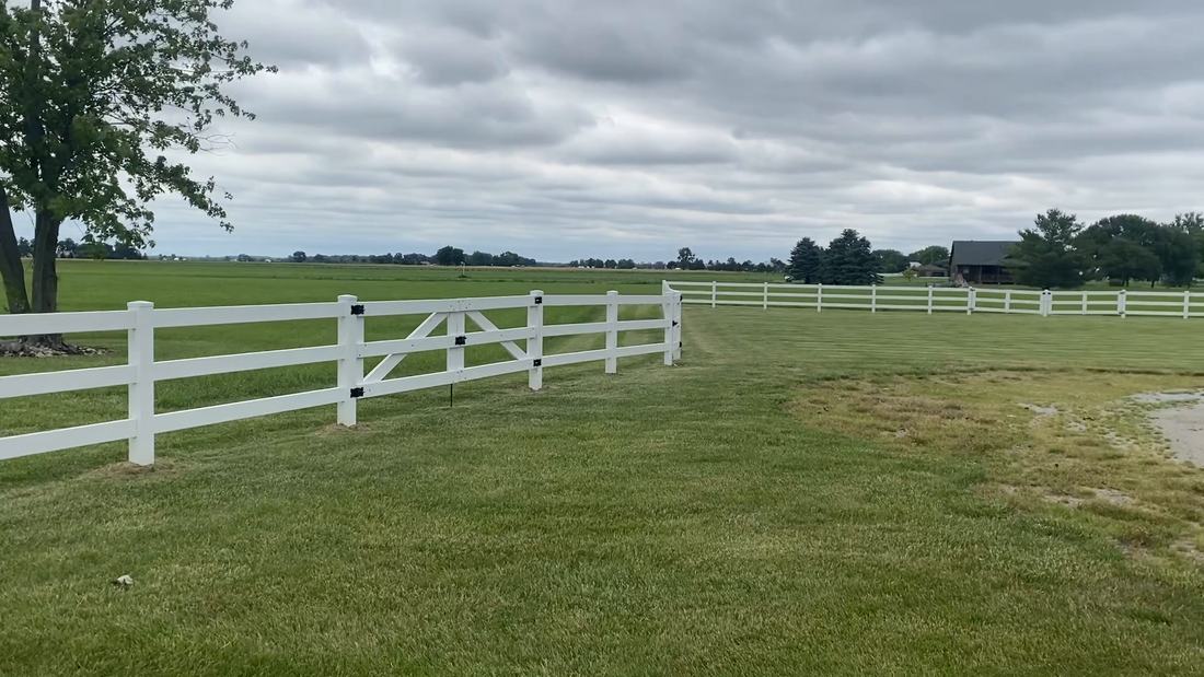 White farm fence and gate running along a rural Central Ohio field