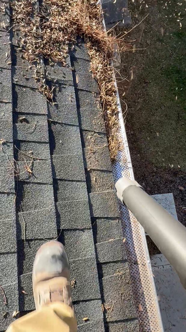 Leaves being blown out of a clogged gutter by Mullet Power Wash in Central Ohio