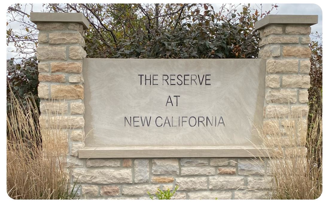 Clean stone entrance sign at The Reserve at New California, washed by Mullet Power Wash