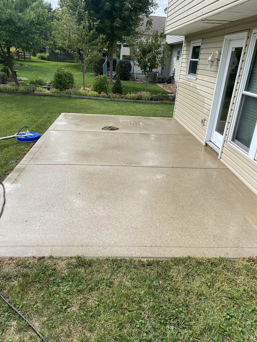 Clean concrete pad beside a Central Ohio home after a residential wash