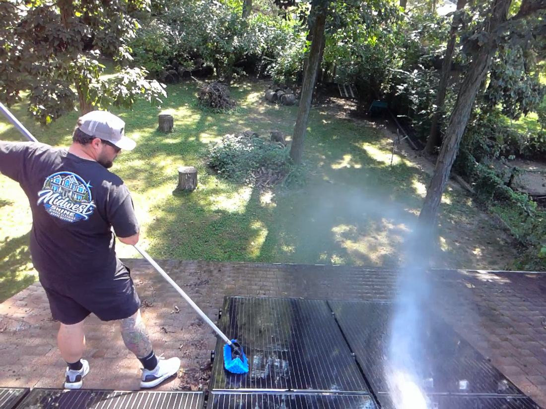 Mullet Power Wash brushing solar panels on a residential shingle roof in Central Ohio
