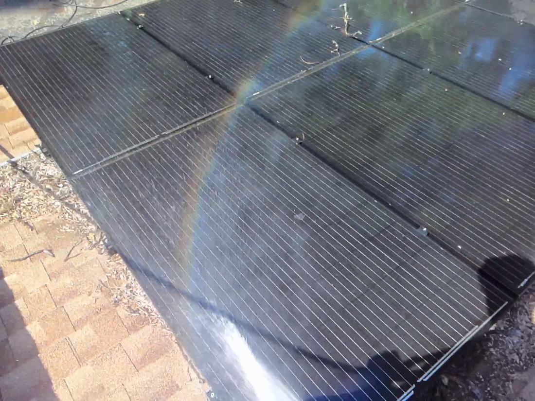 Rinse water running across residential solar panels during a wash
