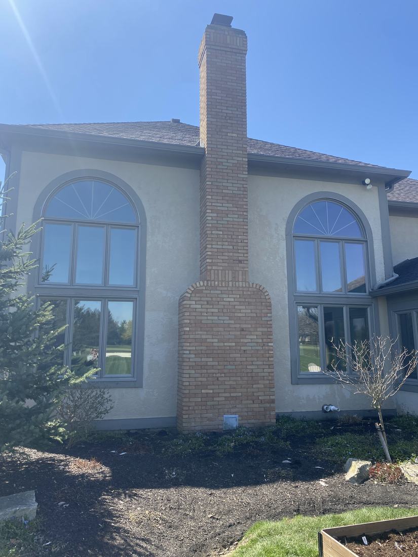 Stucco home and brick chimney after washing by Mullet Power Wash