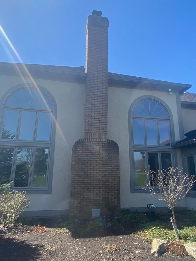 Stucco home and brick chimney before washing