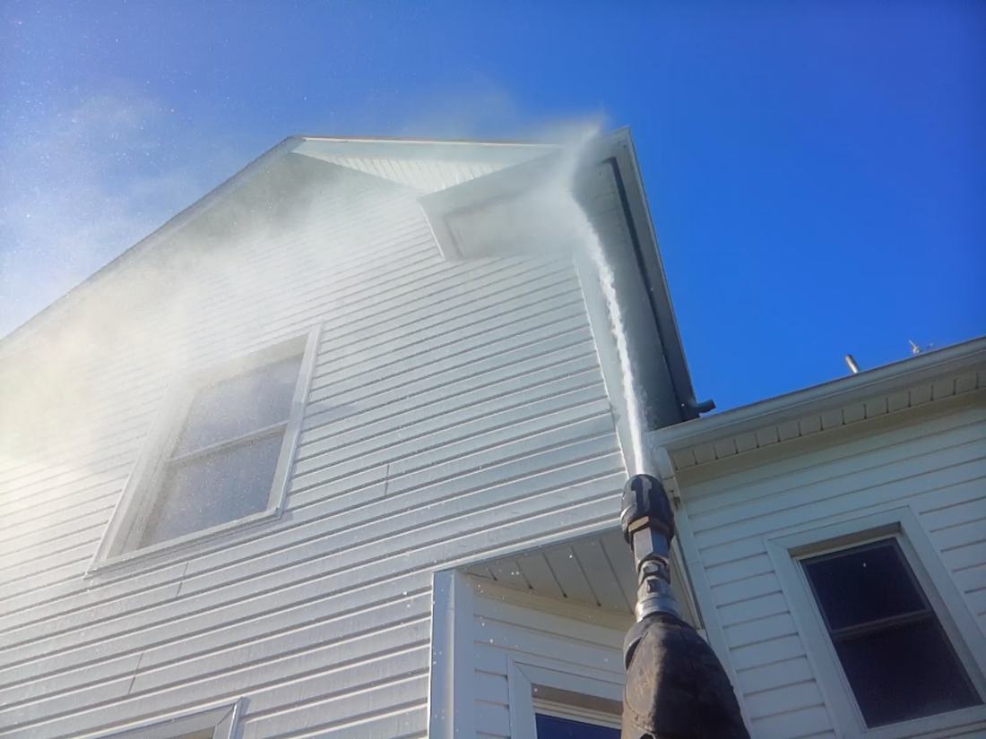 Soft wash solution applied to a white vinyl gable at low pressure in Central Ohio