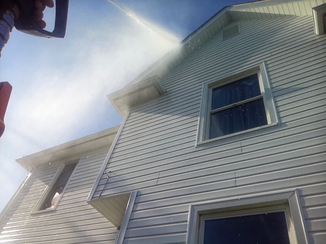Low-pressure rinse reaching the upper siding of a two-story home in Central Ohio